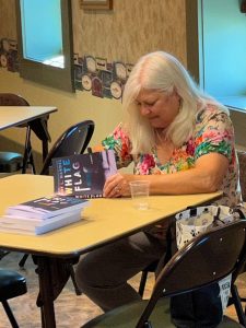 Judy signing a copy of White Flag for an attendee